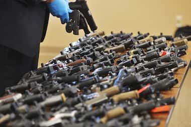 FILE - Dozens of recovered stolen handguns are displayed during a press conference, Nov. 21,...