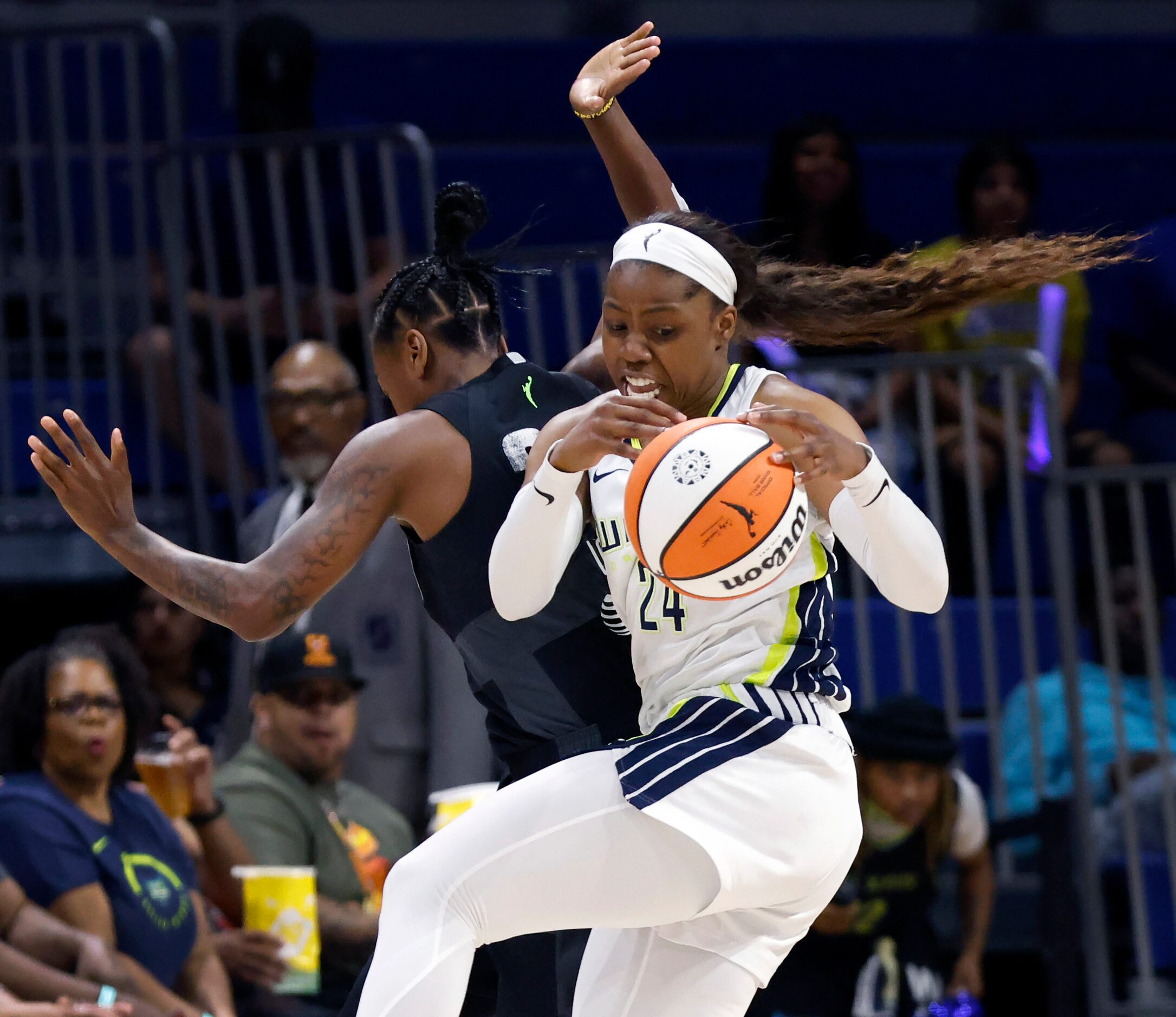 Dallas Wings guard Arike Ogunbowale (24) spins away from a hard charging Seattle Storm guard...