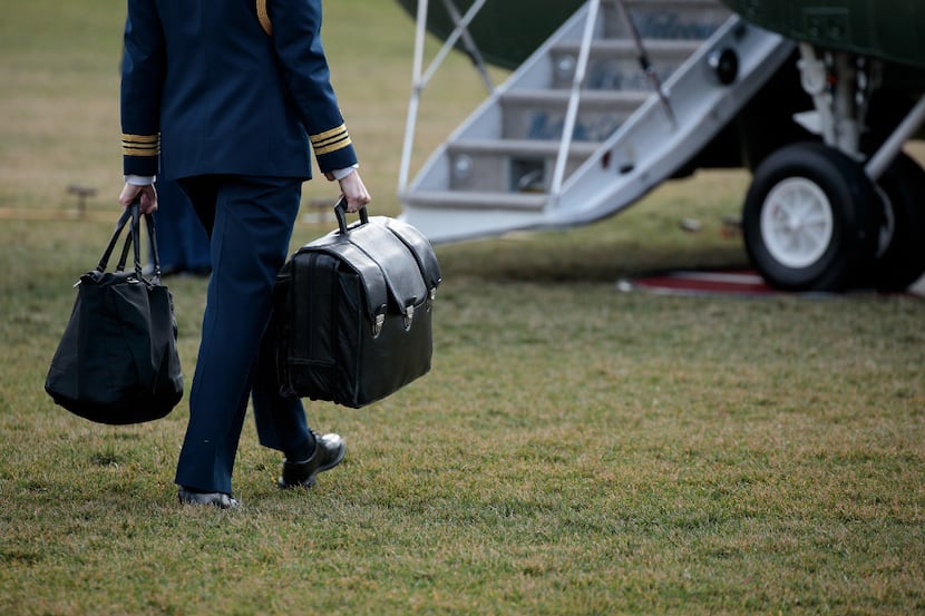 WASHINGTON, DC - JANUARY 26: A military aide carries the alleged 'football,' a case with the...