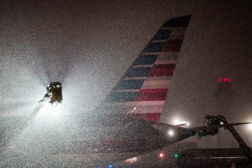 An American Airlines aircraft goes through deicing procedures as snow falls at DFW...