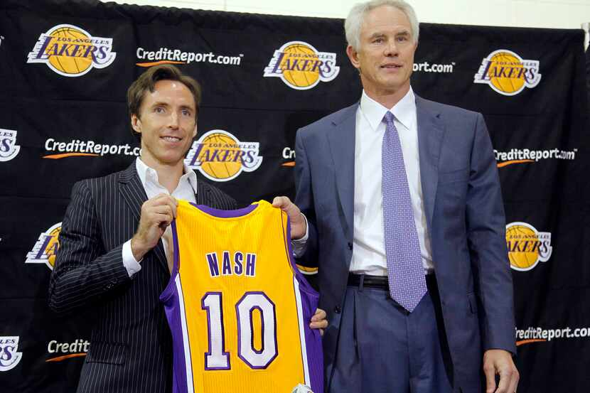 Newly acquired Los Angeles Lakers guard Steve Nash, left, holds his new jersey with general...