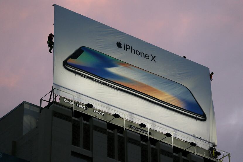 Workers put up a billboard for the new iPhone X outside the Apple Union Square store Friday,...