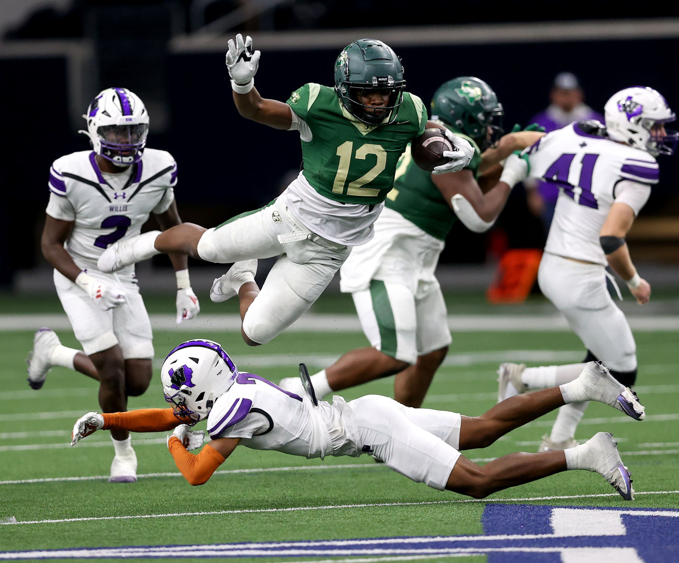 DeSoto running back SaRod Baker (12) lunges over Willis safety Jermaine Bishop Jr for a big...