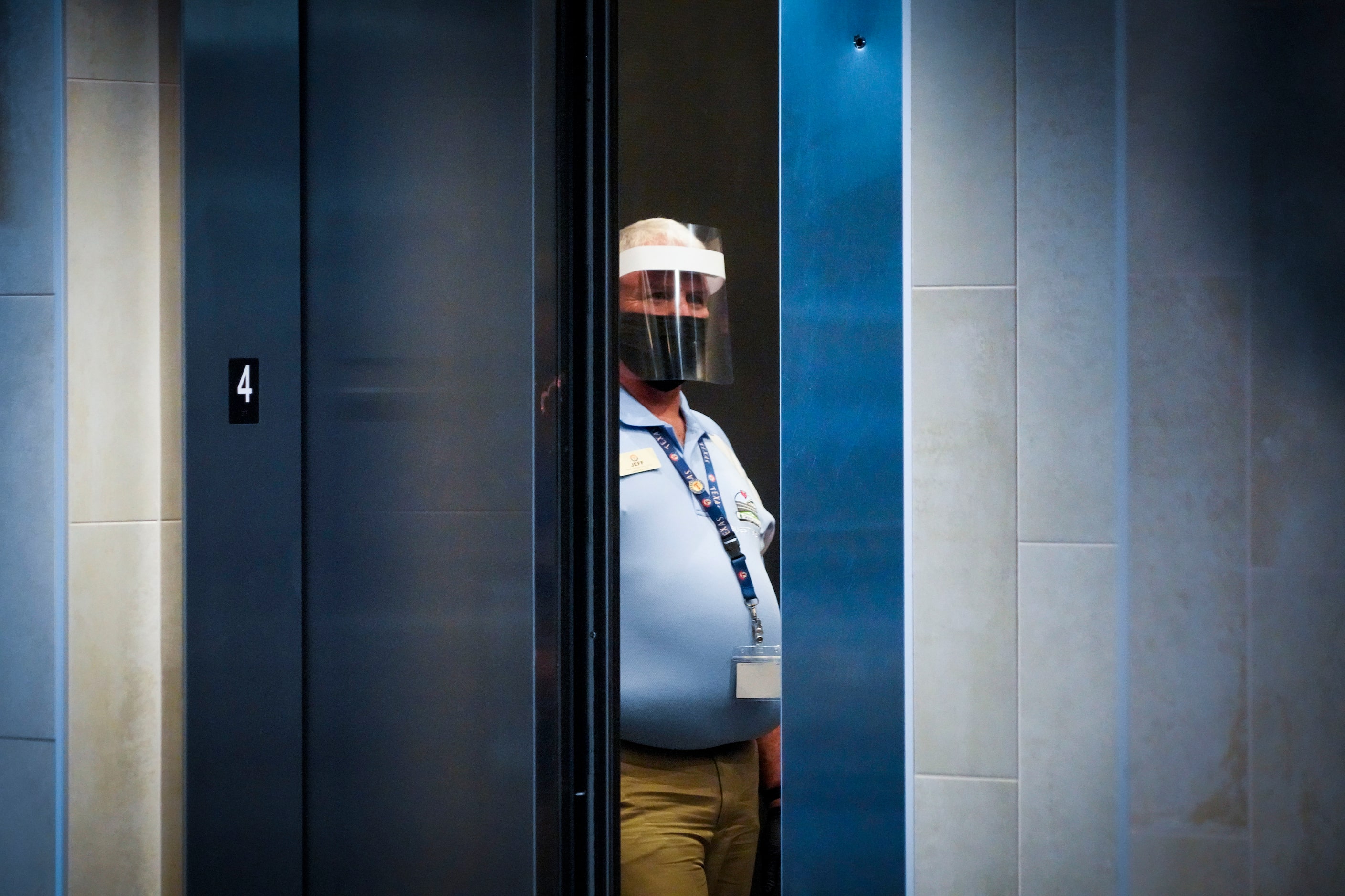 An elevator operator wears a face mask and face shield while working before Game 1 of a...