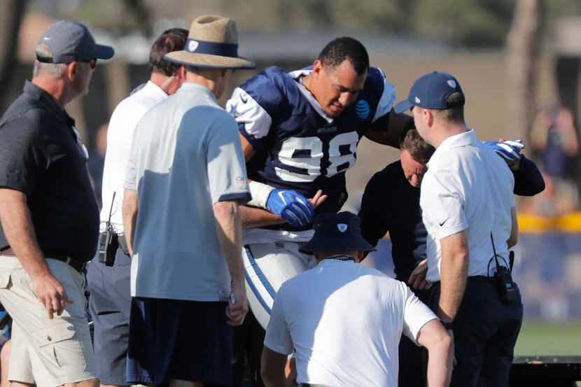 Dallas Cowboys defensive end Tyrone Crawford is injured tackling running back Ezekiel...