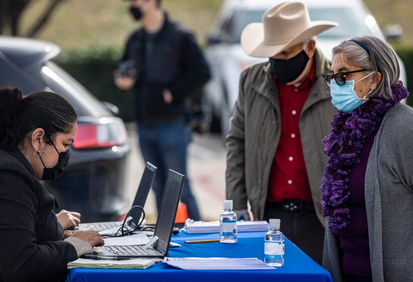 Noemi Gonzalez (left), Senior Secretary to Commissioner Elba Garcia, helps Oak Cliff...