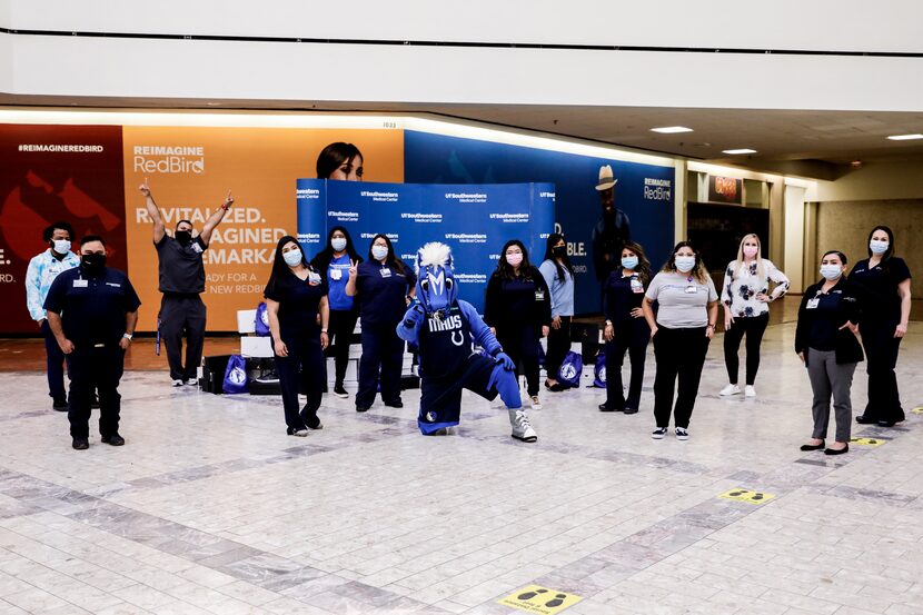 Dallas Mavericks mascot Champ, poses with UT Southwestern healthcare workers after they...