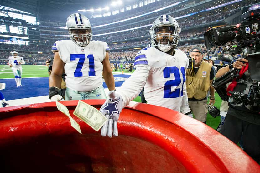 Cowboys running back Ezekiel Elliott dropped $21 — representing his jersey number — into the...