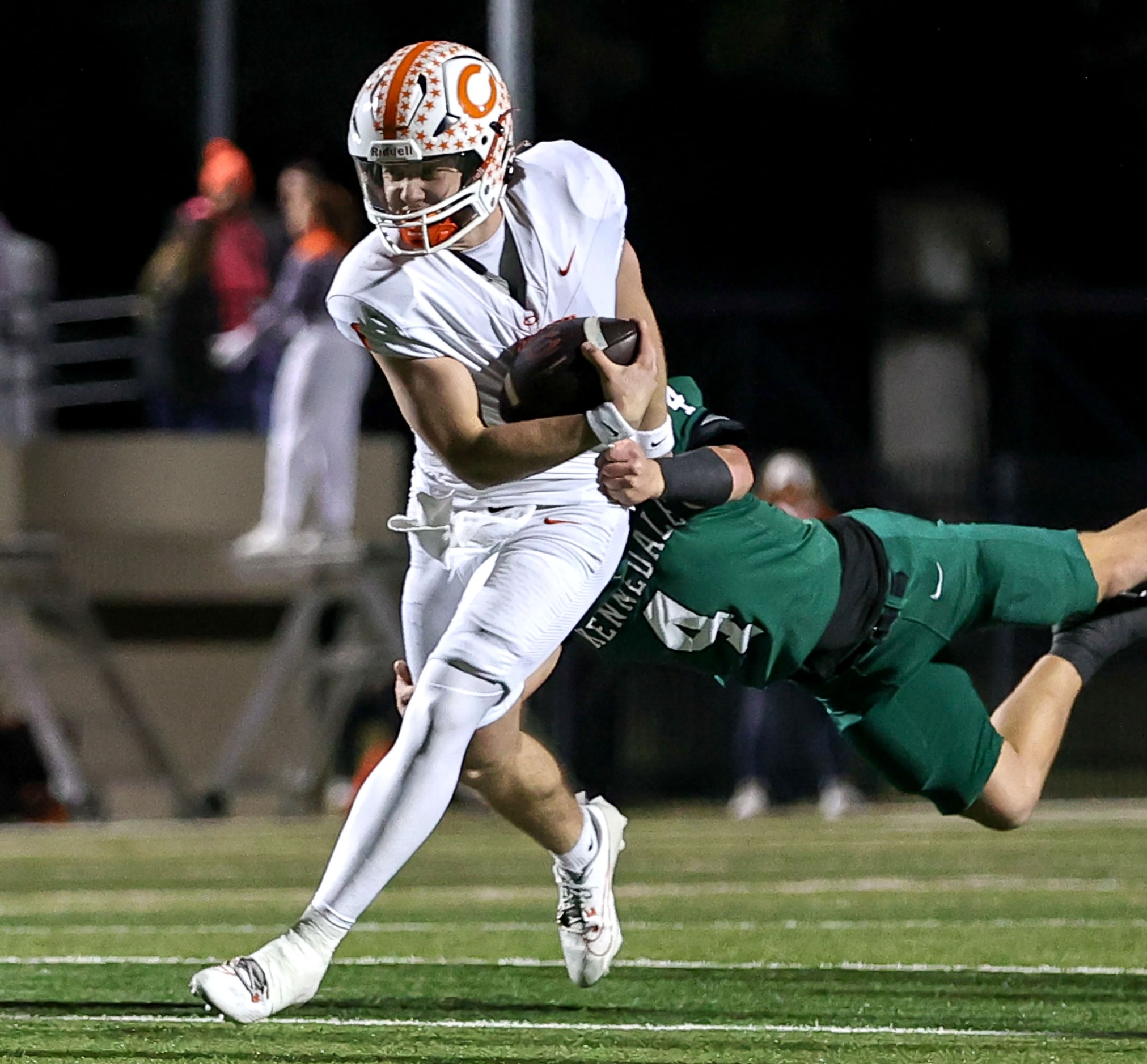 Celina quarterback Bowe Bentley (1) fights off a tackle from Kennedale cornerback Tyler...