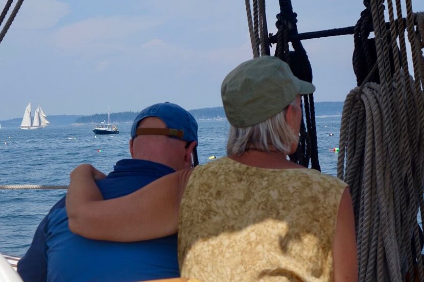 Suzanne Compton and Mike McCrory gaze at the schooner Mary Day, sailing in the background.
