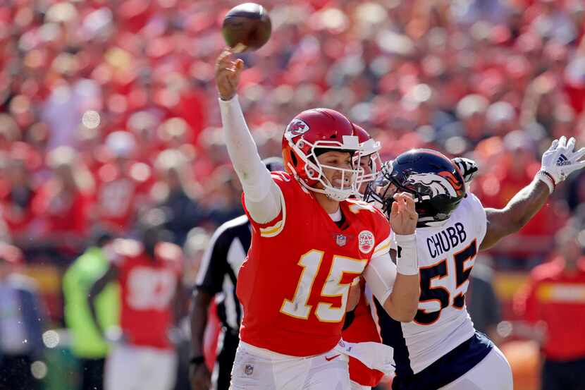 Kansas City Chiefs quarterback Patrick Mahomes (15) throws a pass under pressure from Denver...