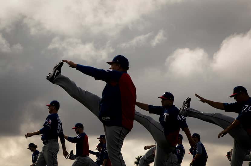 Texas Rangers pitcher Bartolo Colon (left) stretches with teammates during the first spring...