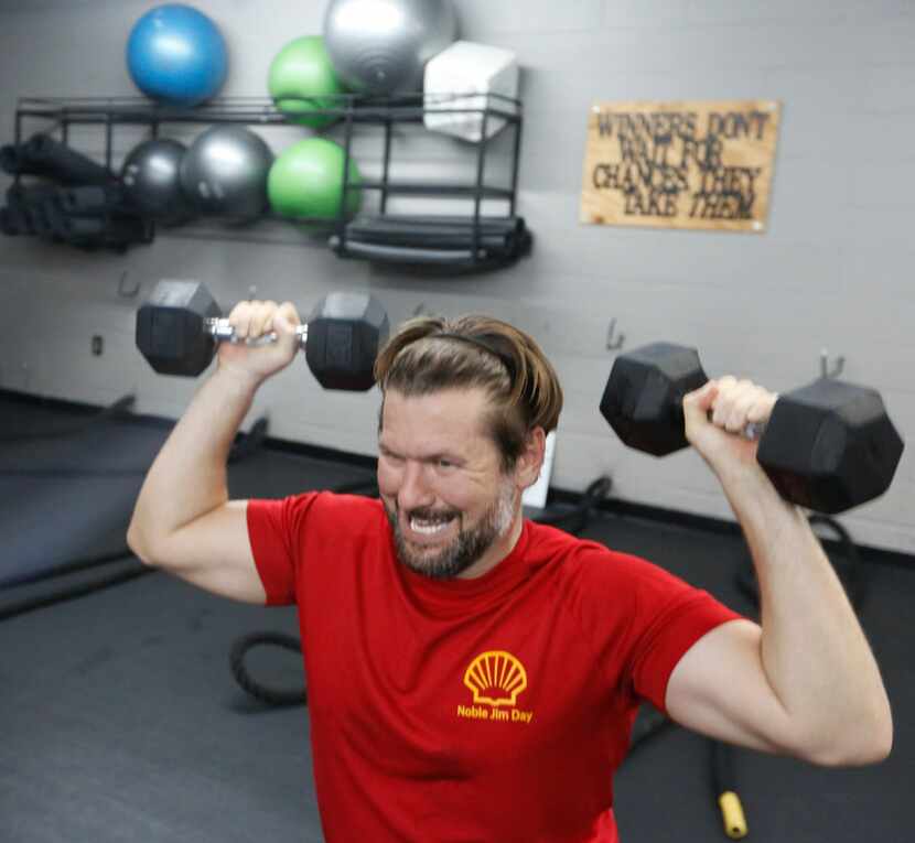 Michael Carr lifts dumbbells during a high intensity workout at Fit Body Boot Camp Thursday...