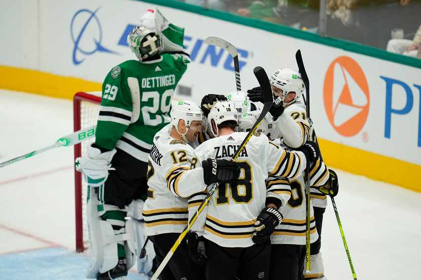 Boston Bruins players celebrate a goal by left wing Brad Marchand (63) during the third...