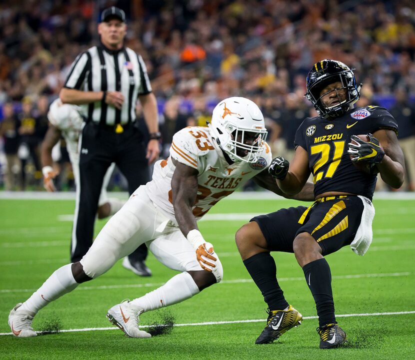 Missouri running back Ish Witter (21) is brought down by Texas linebacker Gary Johnson (33)...