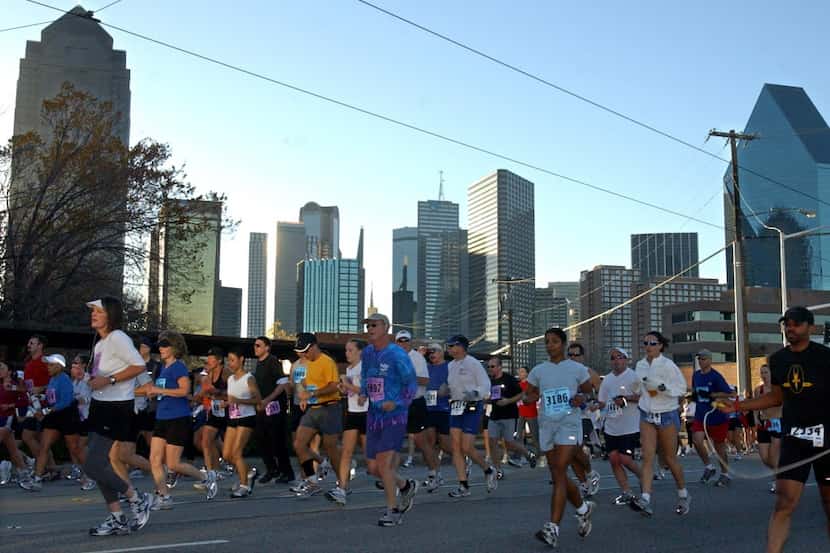 ORG XMIT: *S0411136031* 12/12/2004 -  Marathoners run past the Dallas skyline during the...