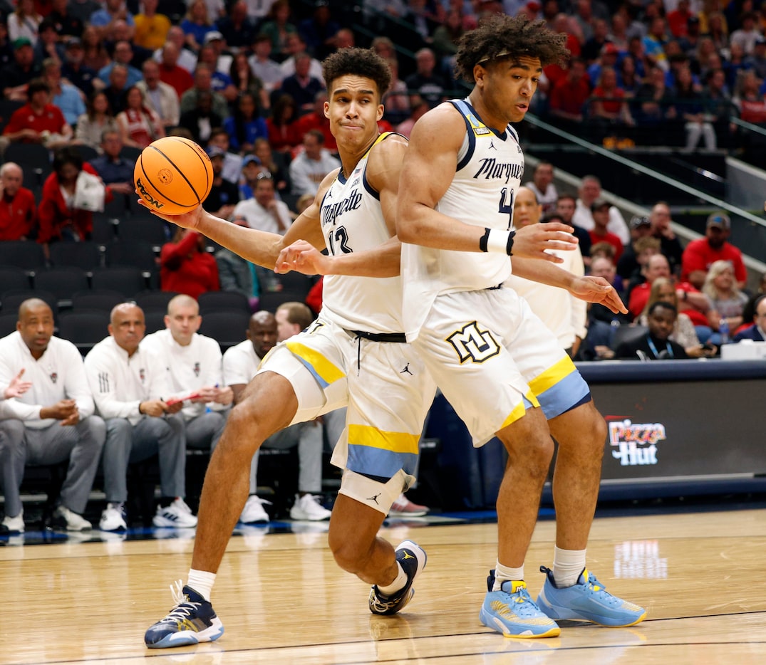 Marquette forward Oso Ighodaro (13) passes the ball around his teammate guard Stevie...