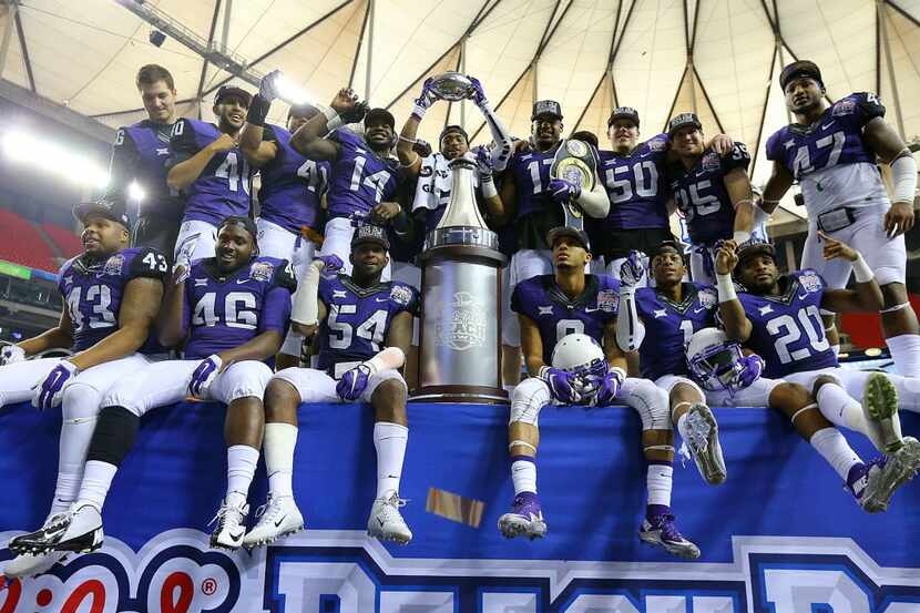 TCU players gather on stage with the trophy after beating Ole Miss 42-3 to win the...