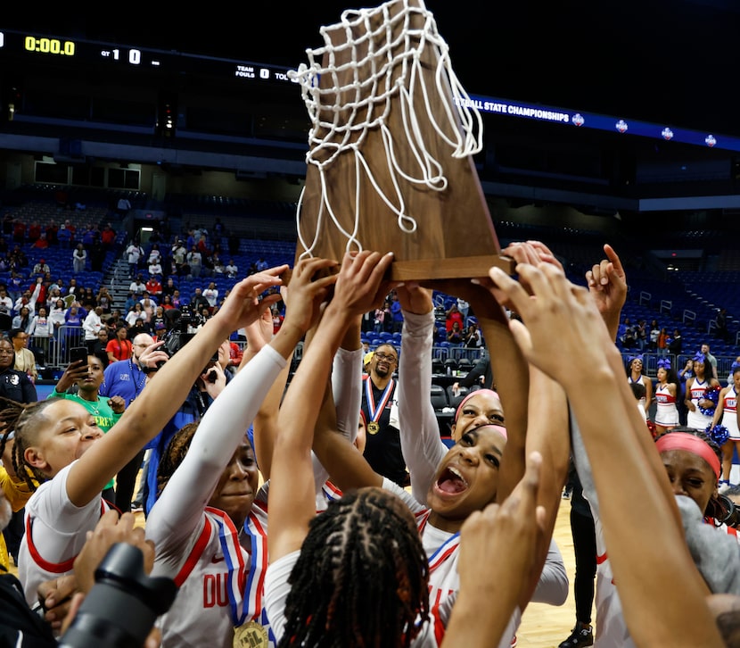 Members of the Duncanville girls basketball team celebrate their victory after the UIL Class...