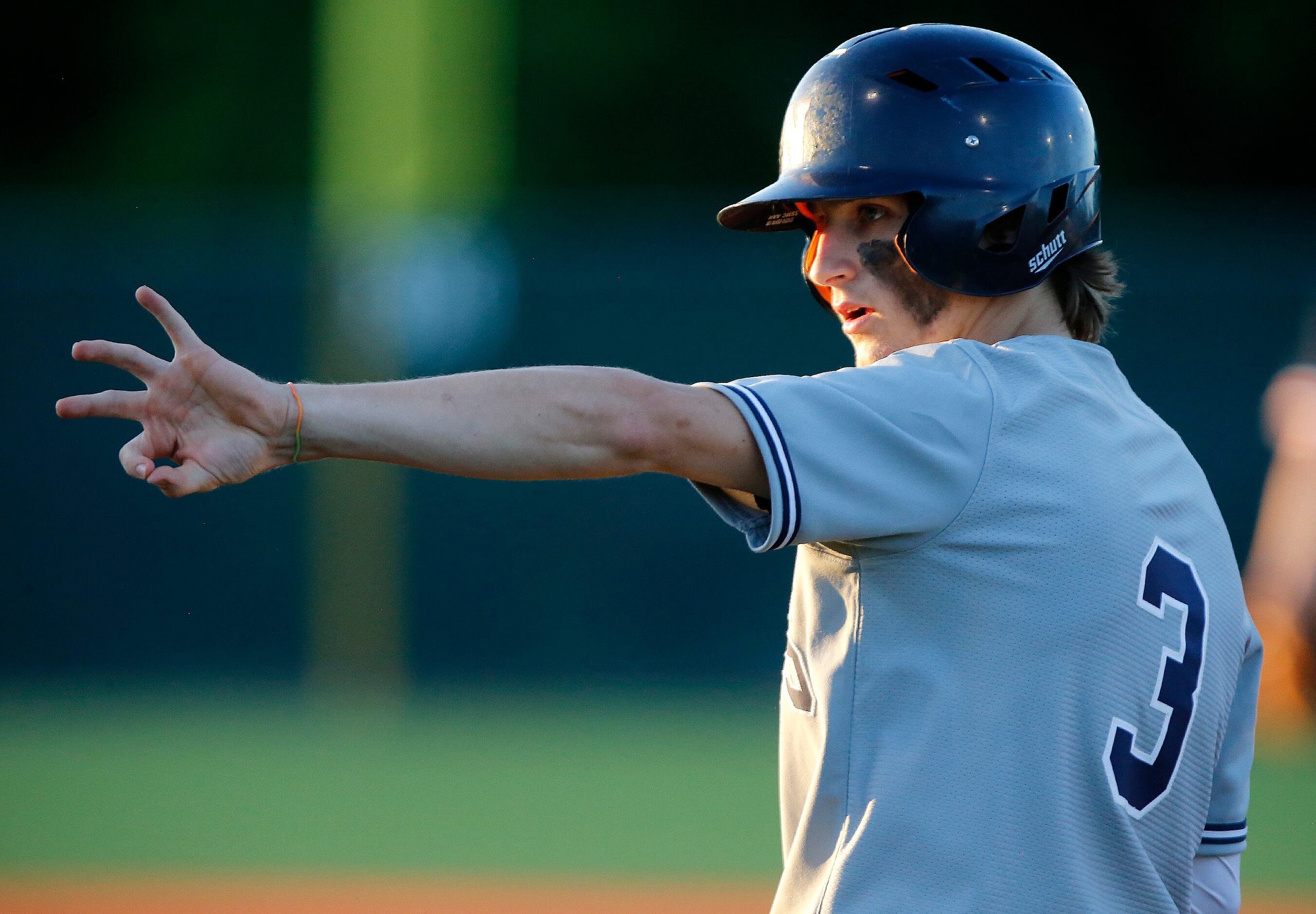 McKinney North High School catcher Cameron Bonds (3) signals to the dugout after getting on...