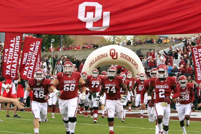 The Oklahoma Sooners run onto the field before the start of a game against the Texas Tech...