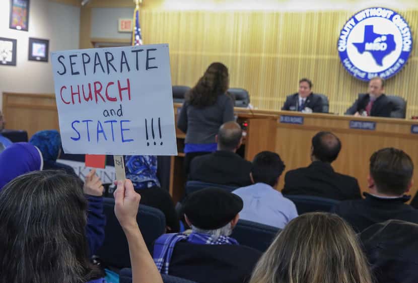 Kristy Fuxa holds a "separate church and state" sign while Amy Bennett speaks at the...