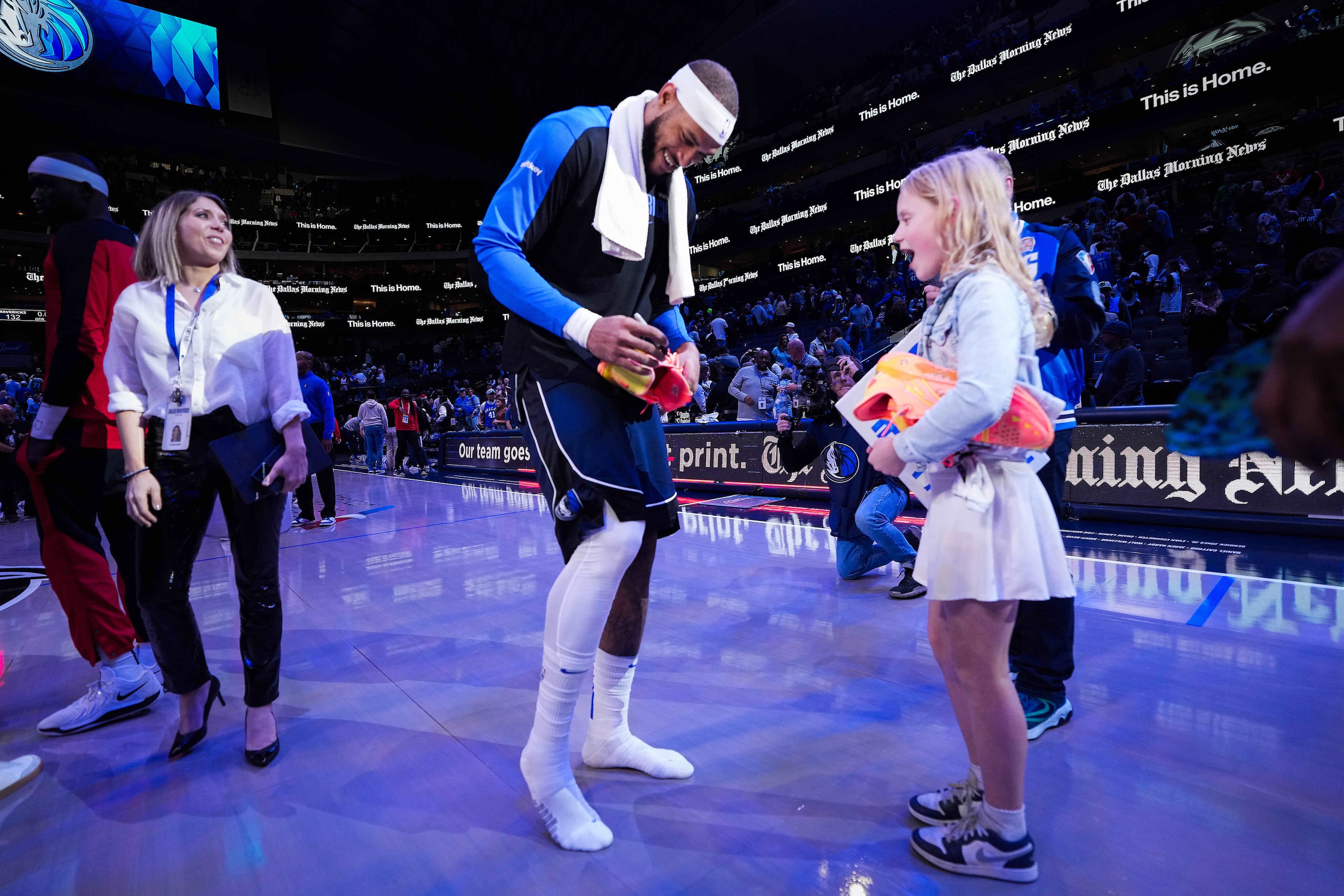 Dallas Mavericks center Daniel Gafford (21) signs his shoes as he gives them to Lily...