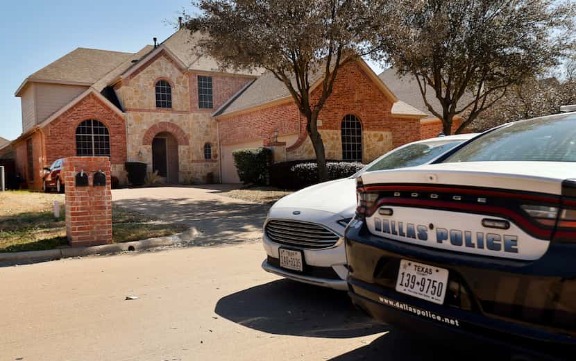 A pair of Dallas olice cars were parked outside the home of Dallas officer Bryan Riser in...