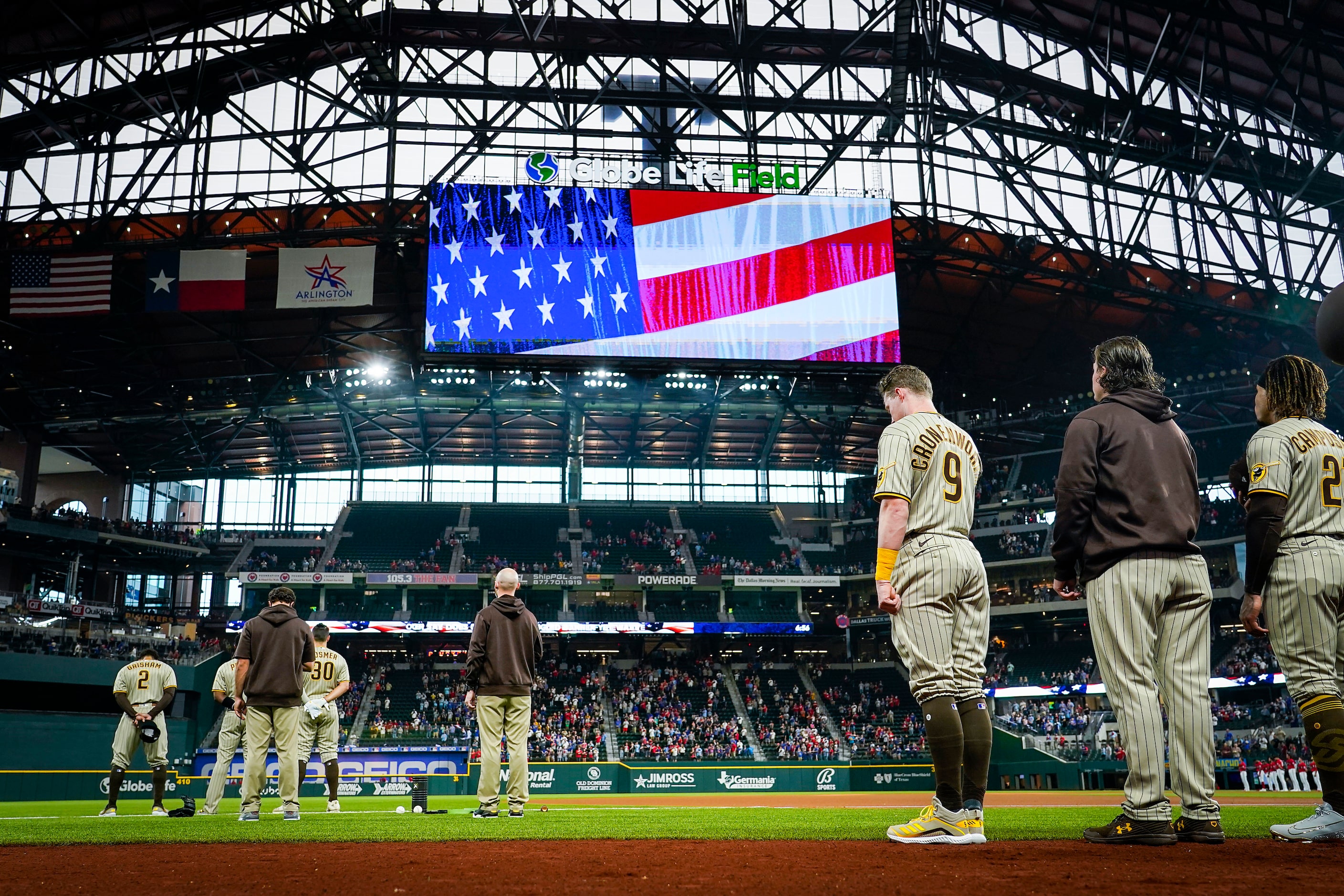 San Diego Padres second baseman Jake Cronenworth (9) joins teammates standing for the...