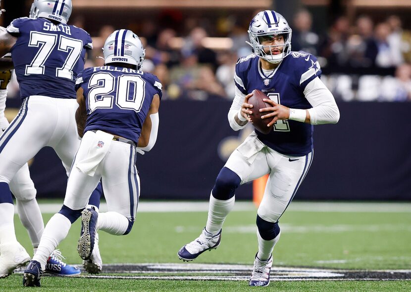 Dallas Cowboys quarterback Dak Prescott (4) fakes the handoff to running back Tony Pollard...