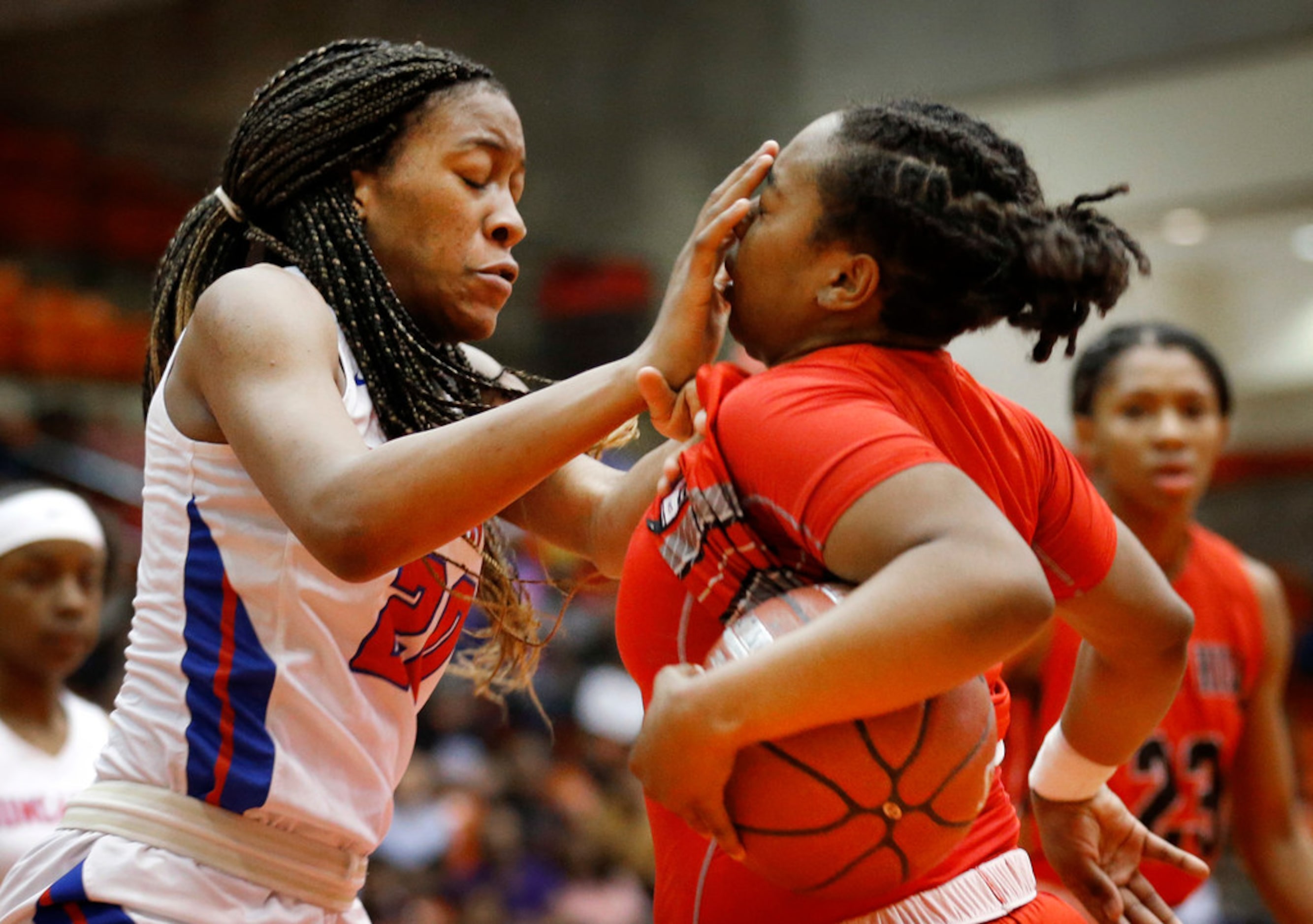 Duncanville's Anaya Bernard (20, left) inadvertently smashes Cedar Hills' Portia Adams (11)...