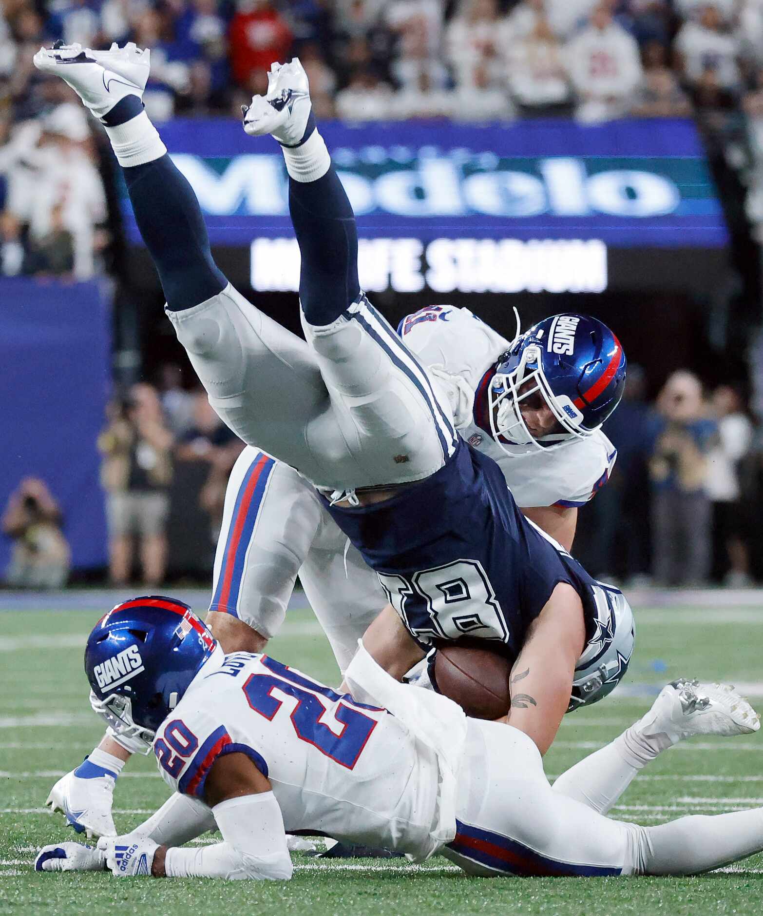 Dallas Cowboys tight end Jake Ferguson (87) is upended by New York Giants safety Julian Love...