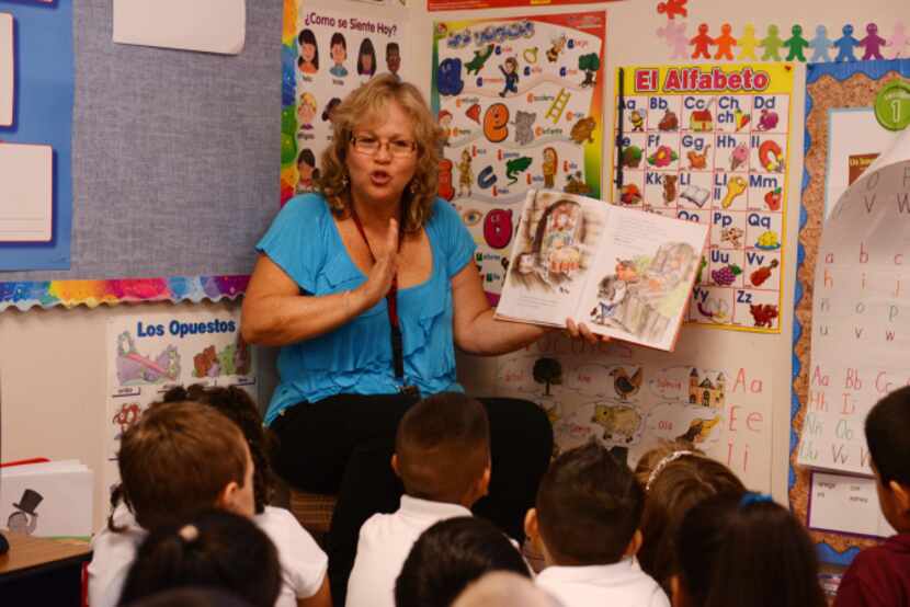 Dual-language teacher Gina Fernandez reads a Spanish language book to her first-grade...