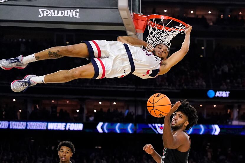 Connecticut guard Andre Jackson Jr. dunks the ball over Miami forward Norchad Omier, right,...