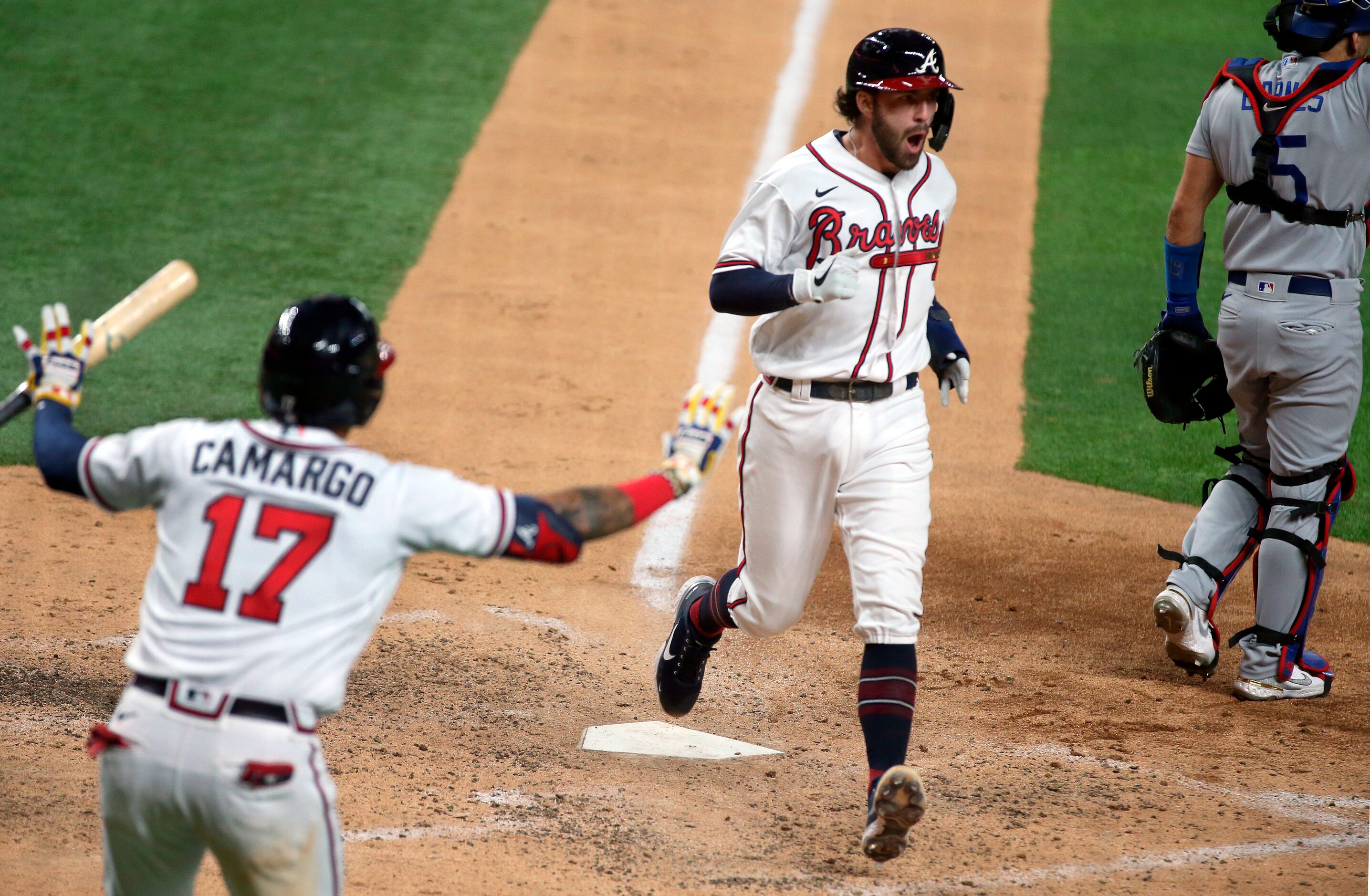 Atlanta Braves shortstop Dansby Swanson (center) scores a sixth inning run on a single by...