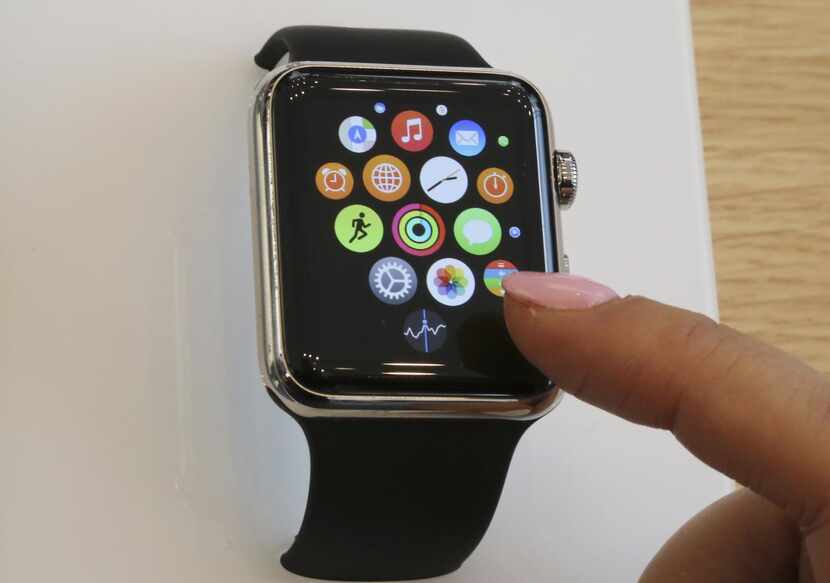 In this April 10, 2015, file photo, a customer demonstrates the Apple Watch at an Apple...