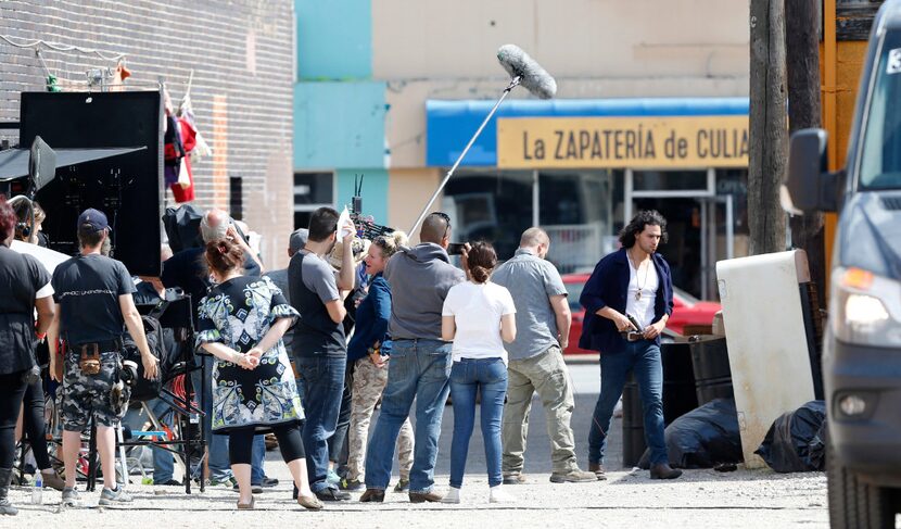 An actor puts away his gun during filming of "Queen of the South" in an alley next to...