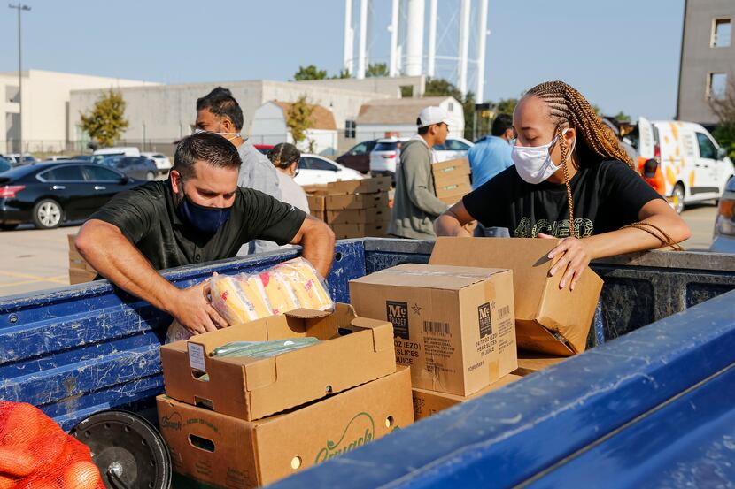 Volunteers Jeff Chisholm (left) and Kennedy Stewart loaded food into the back of a truck...