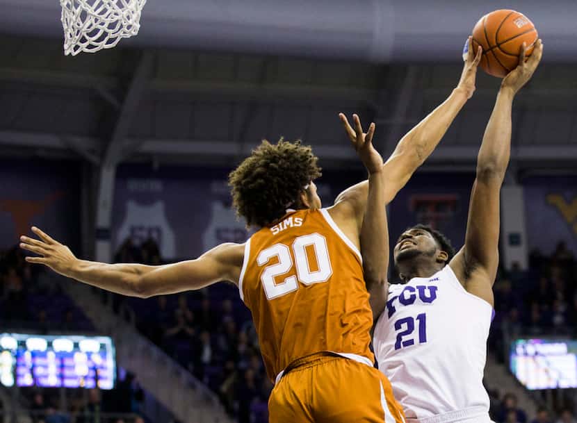 TCU Horned Frogs center Kevin Samuel (21) has his shot blocked by Texas Longhorns forward...