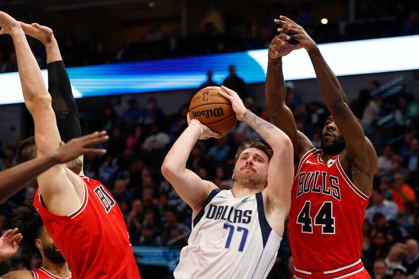 Dallas Mavericks guard Luka Doncic (77) shoots the ball against a defending Chicago Bulls...