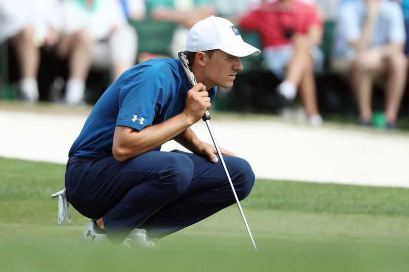 Jordan Spieth lines up a putt on the 18th green during the second round of the Masters at...