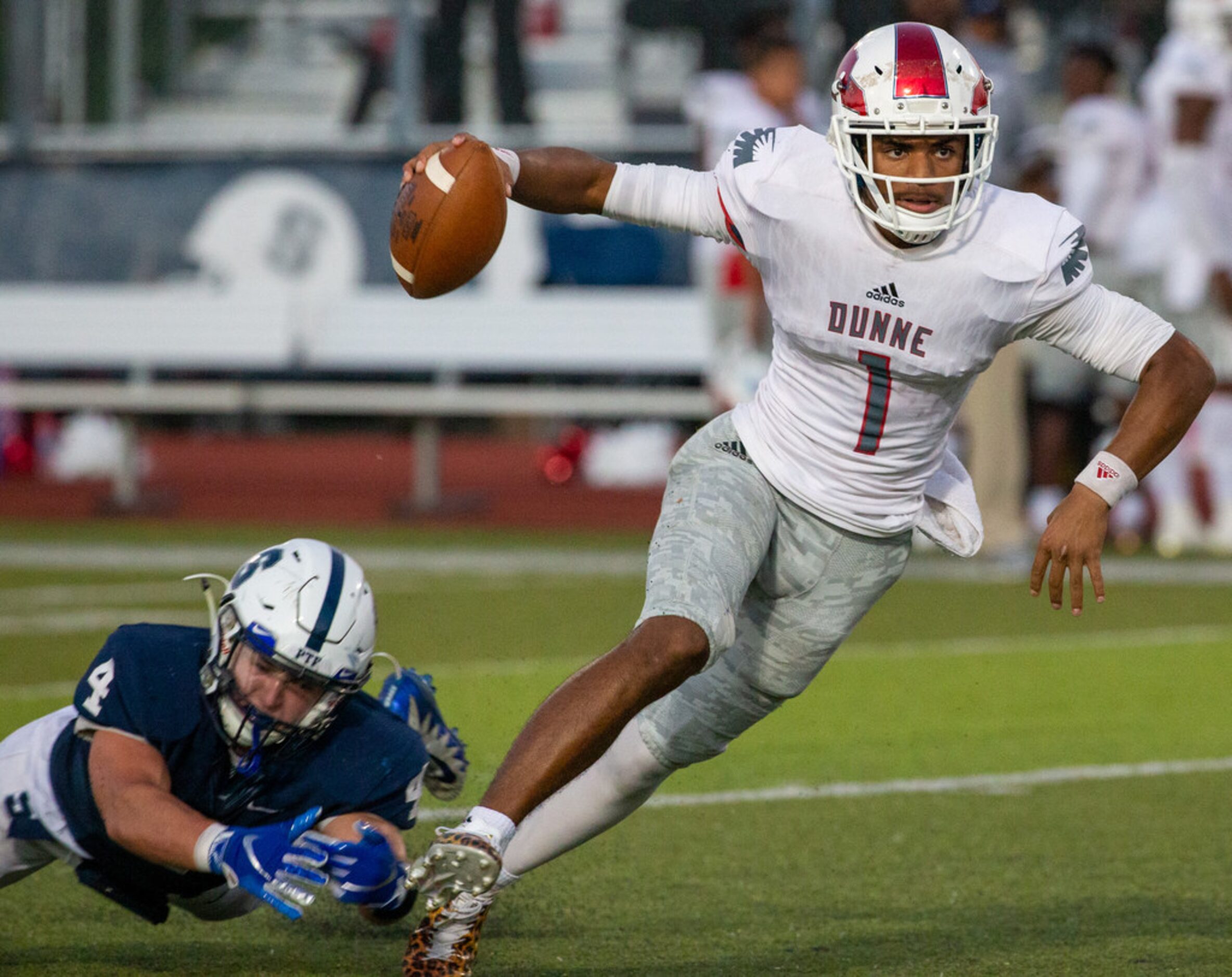 Bishop Dunne quarterback Simeon Evans (1) makes a run with the ball as All Saints' Episcopal...