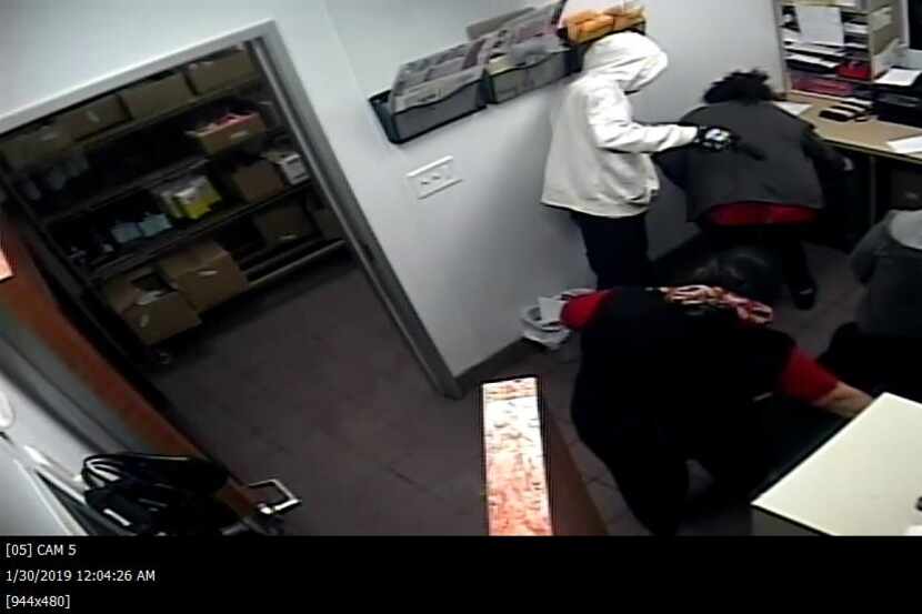 This still image shows a man pointing a gun at a Wendy's employee as she is instructed to...