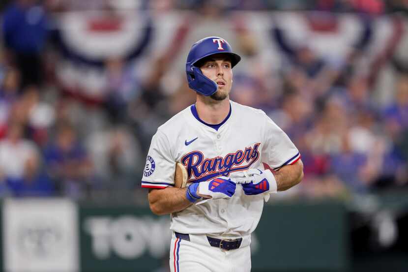 Texas Rangers' Evan Carter heads to first after being walked during the fifth inning of the...