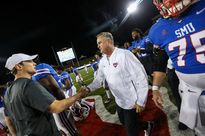 Southern Methodist Mustangs head coach Sonny Dykes shakes hands with Houston Cougars head...
