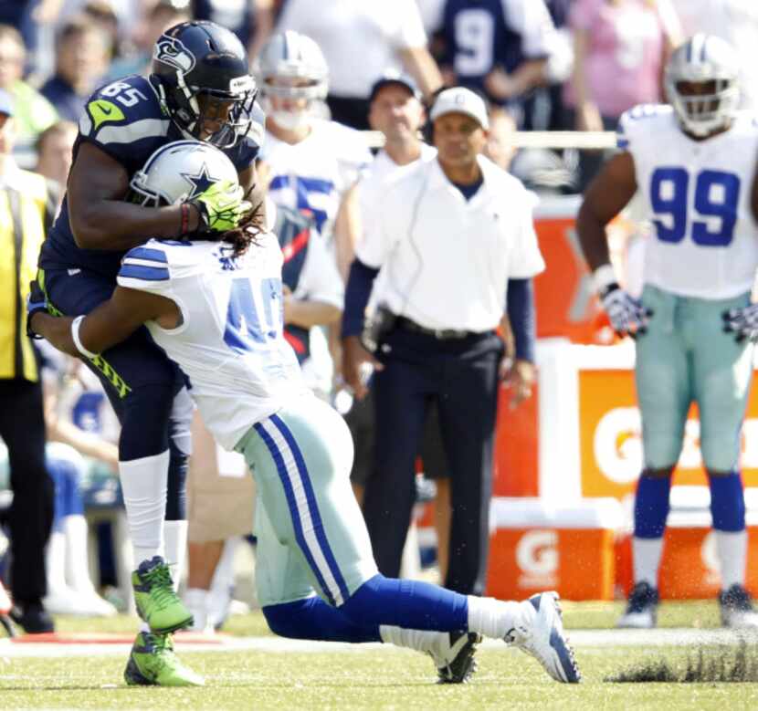 Dallas Cowboys defensive back Danny McCray (40) tackles Seattle Seahawks tight end Anthony...