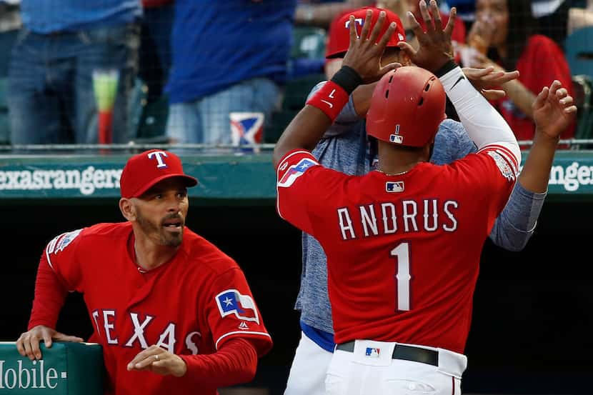 Texas Rangers manager Chris Woodward congratulates Elvis Andrus (1) after he scored against...