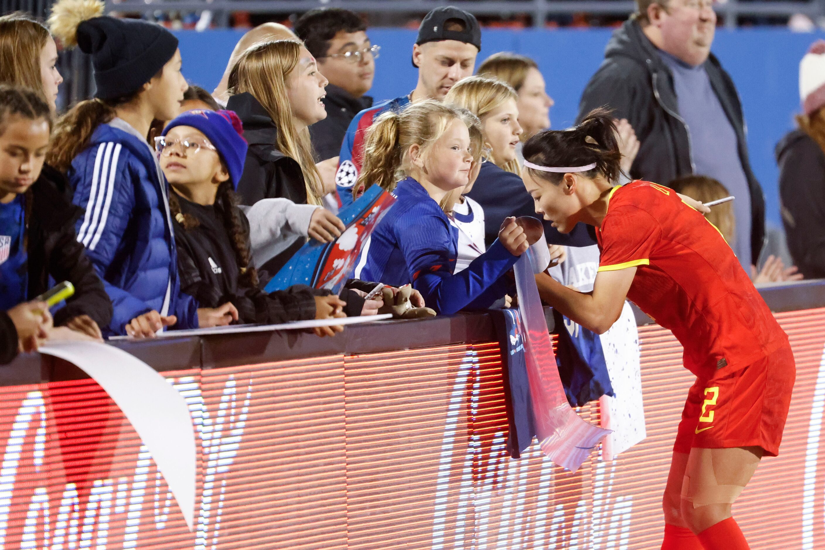 China defender Li Mengwen signs autograph to fans after a soccer game against United States,...