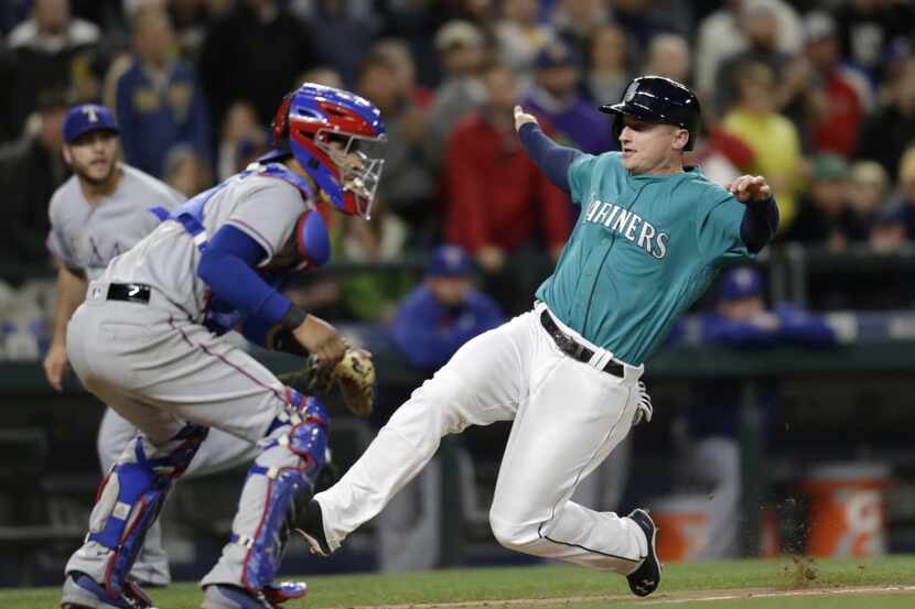 Seattle Mariners' Kyle Seager scores on a sacrifice fly by Seth Smith while Texas Rangers...
