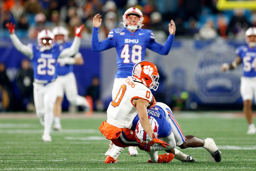 SMU long snapper Will Benton IV (48) reacts as wide receiver Jordan Hudson (8) tackles...